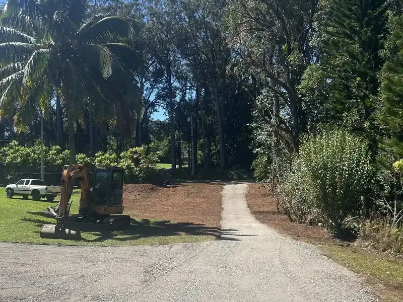 Gravel driveway cut through dense tropical trees in Haiku, Maui