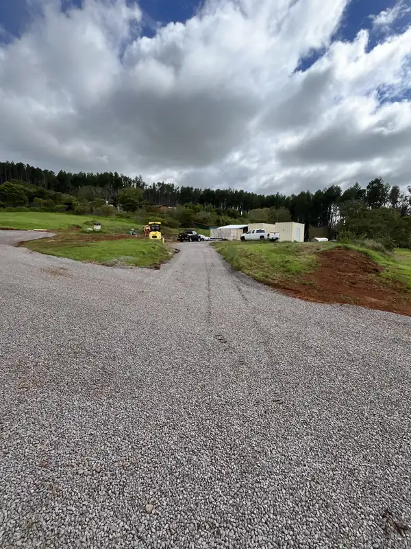 Freshly laid compacted gravel driveway curving across an Upcountry property