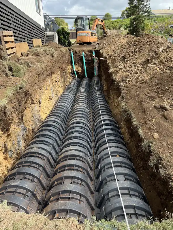 Leach field chambers laid end to end in a long trench beside a house